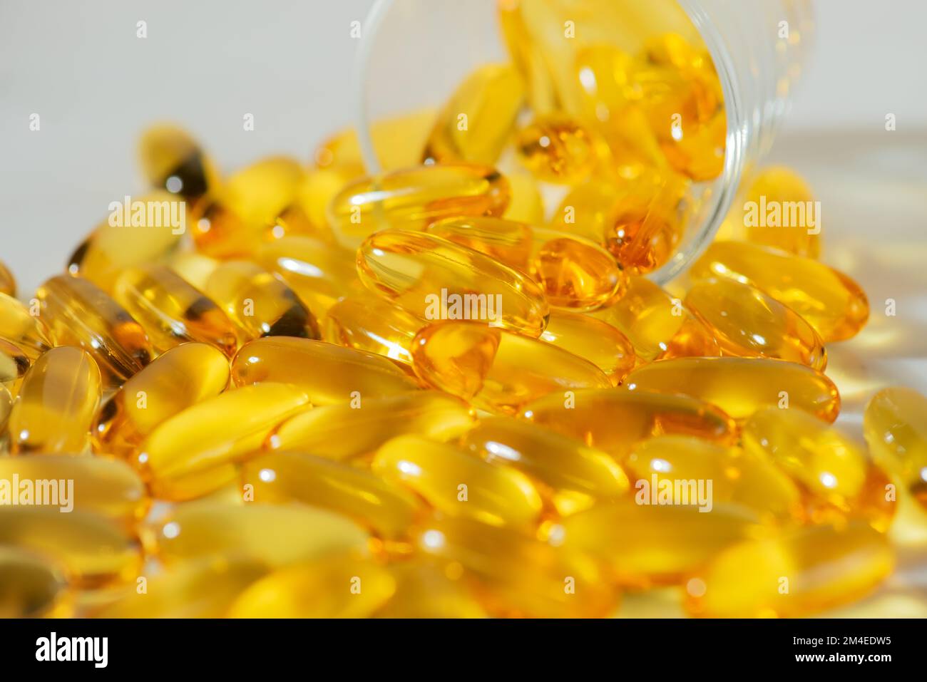 Omega-3 Fischöl Kapseln in einer Glasflasche auf weißem Marmorhintergrund gesunde Ernährung, medizinisches Nahrungsergänzungsmittel, Vitamine D, Nahaufnahme Stockfoto