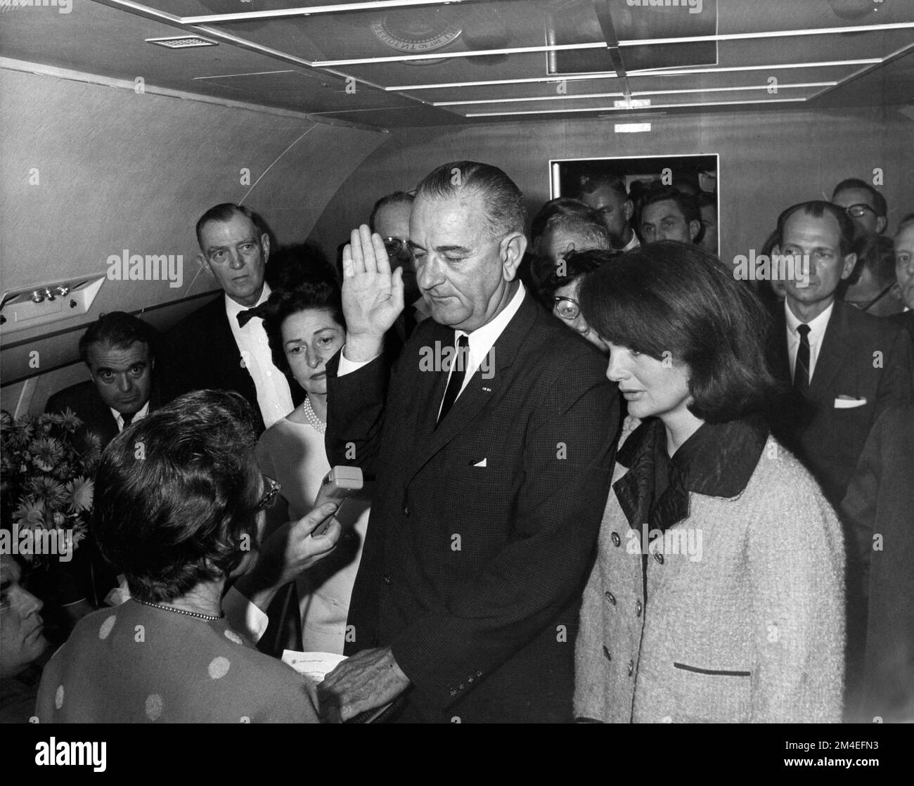 Cecil Stoughtons ikonisches Foto von Lyndon B. Johnson, der als Präsident vereidigt wurde, während sich Air Force One auf den Abflug von Love Field in Dallas vorbereitet. Jacqueline Kennedy (rechts), immer noch in ihrer blutverschmierten Kleidung (hier nicht sichtbar), schaut zu. Stockfoto