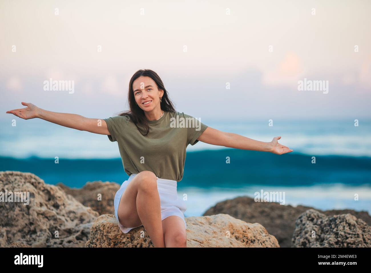 Junge glückliche Frau am Strand genießt ihren Sommerurlaub Stockfoto