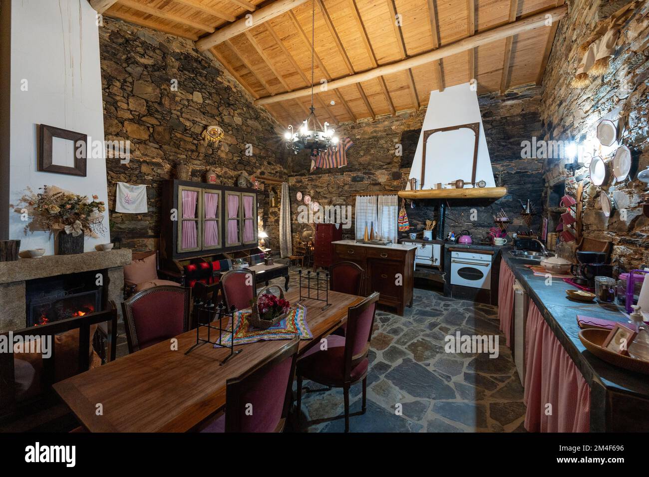 Offene Küche und Wohnzimmer in altem Retro-Haus mit Schiefermauern in einem Dorf in Portugal, Europa Stockfoto