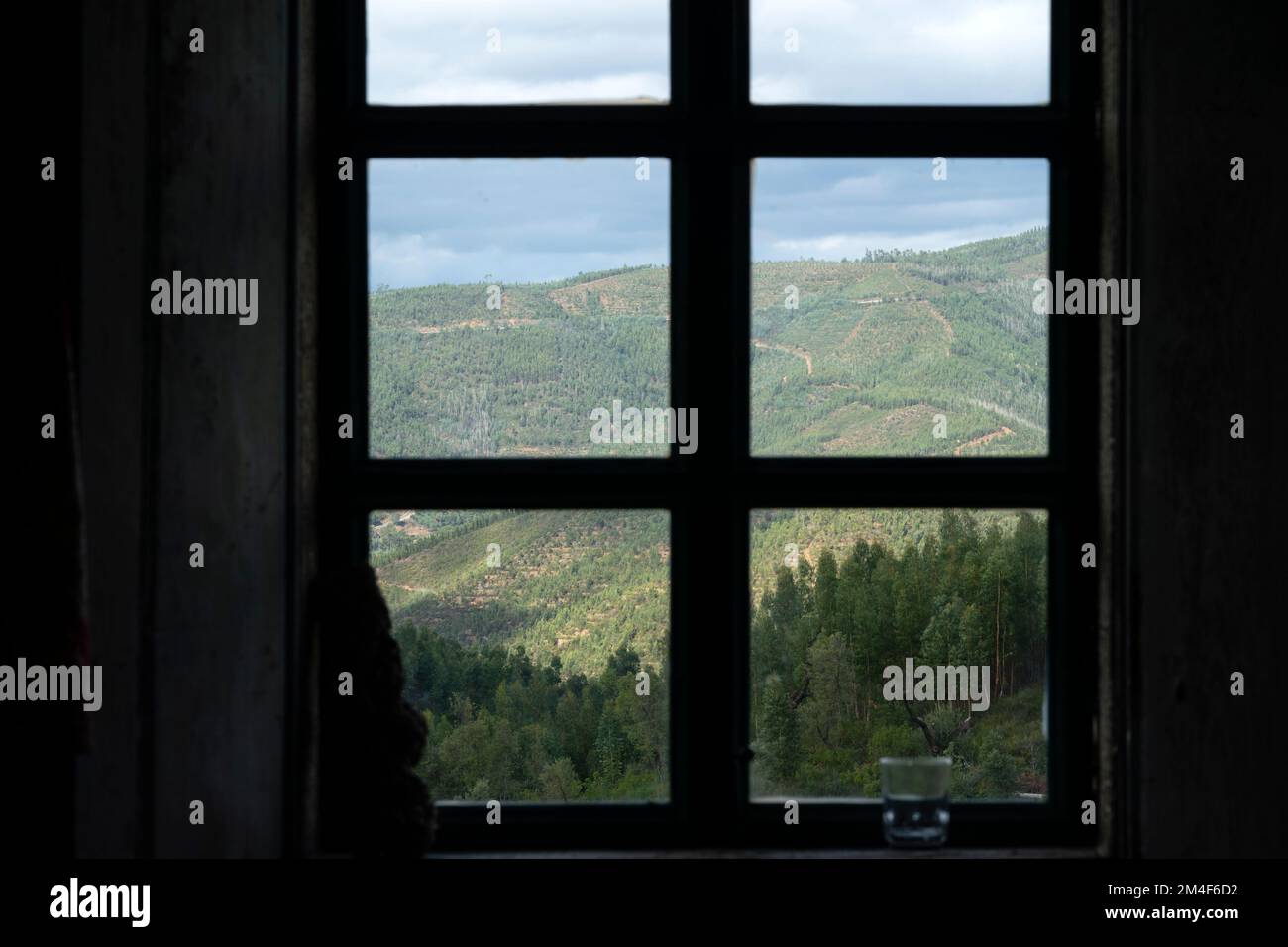 Berglandschaft durch den Rahmen eines geschlossenen Fensters in einem Landhaus Stockfoto