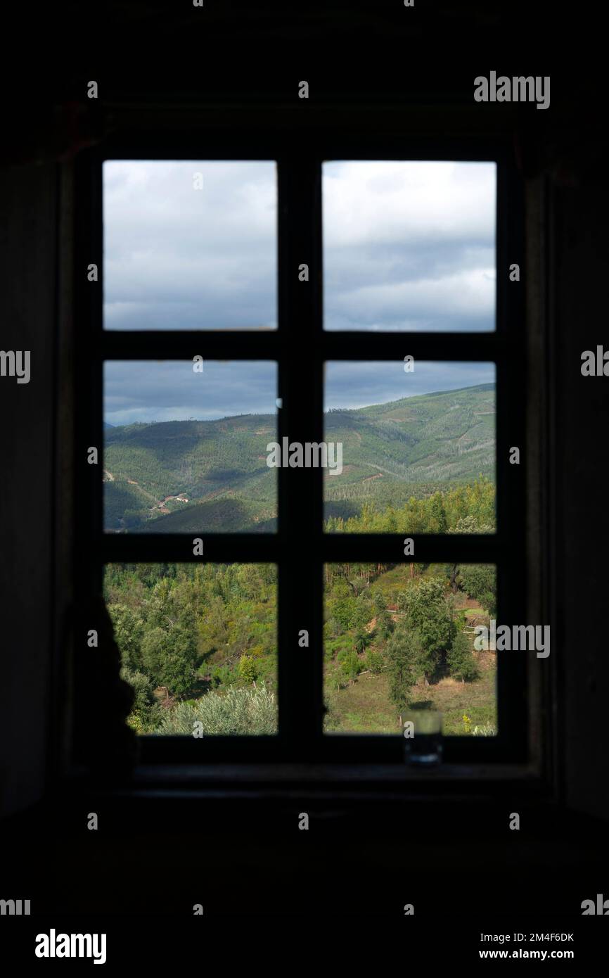 Berglandschaft durch den Rahmen eines geschlossenen Fensters in einem Landhaus Stockfoto