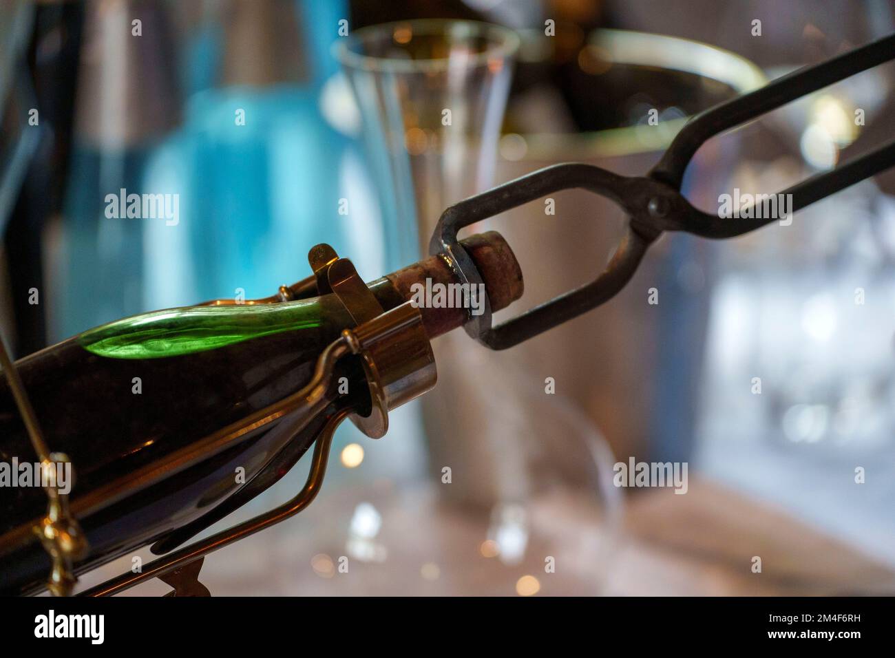 Sommelier öffnet eine Flasche Wein mit roten, heißen Portweinzangen Stockfoto