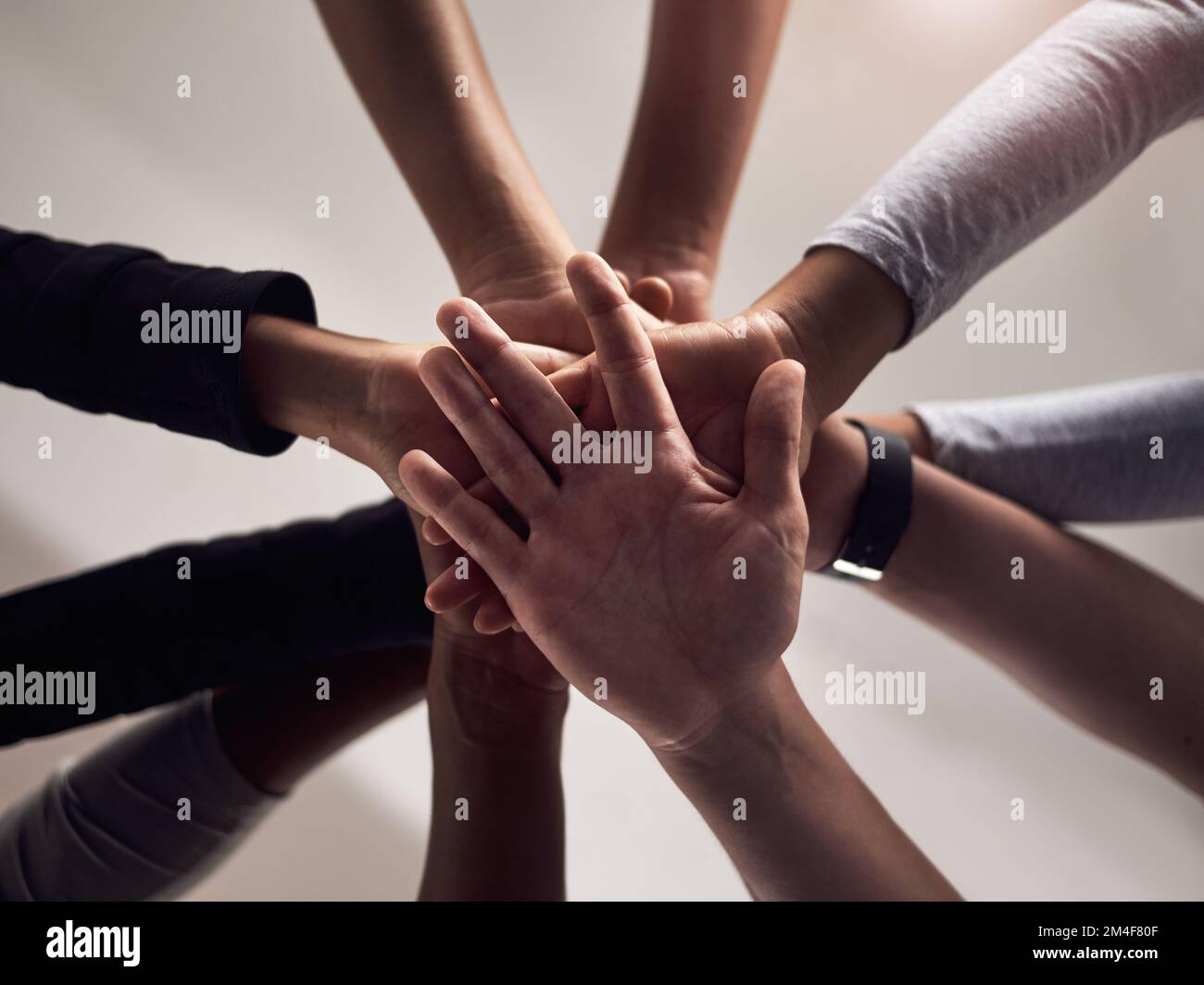 Machen Sie sich fit. Eine Gruppe von Menschen, die ihre Hände in Solidarität in einem Fitnessstudio zusammenlegen. Stockfoto