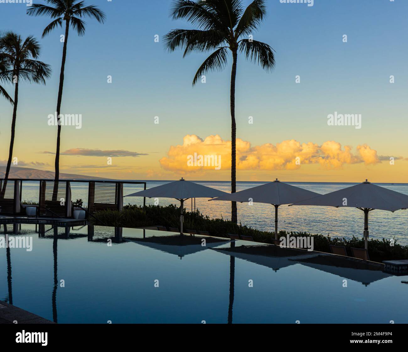 Reflexionen des Sonnenuntergangs am Infinity Pool neben der Küste, Wailea Beach, Wailea, Maui, Hawaii, USA Stockfoto