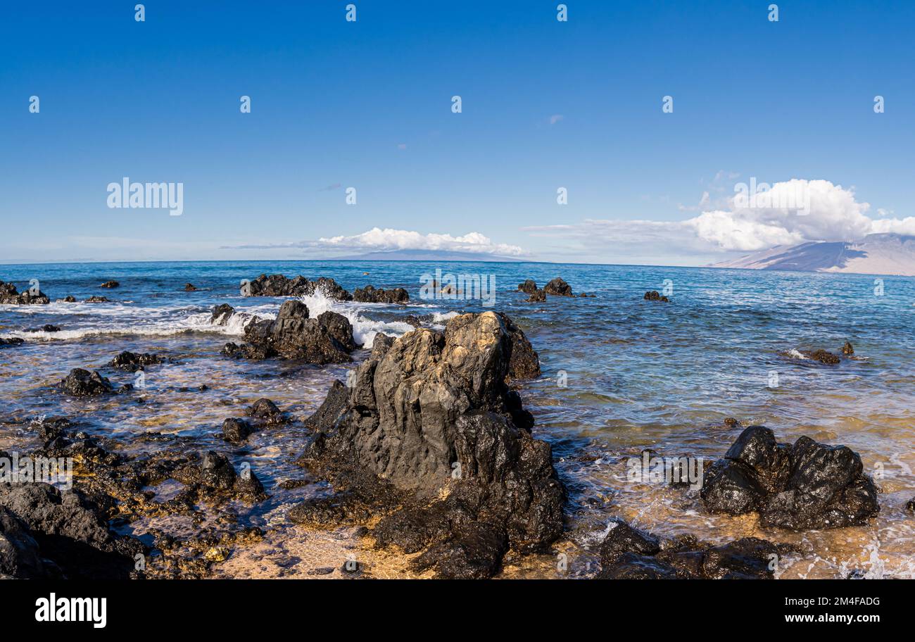 Wellen über Lavafeldern am Keawakapu Beach, Maui, Hawaii, USA Stockfoto