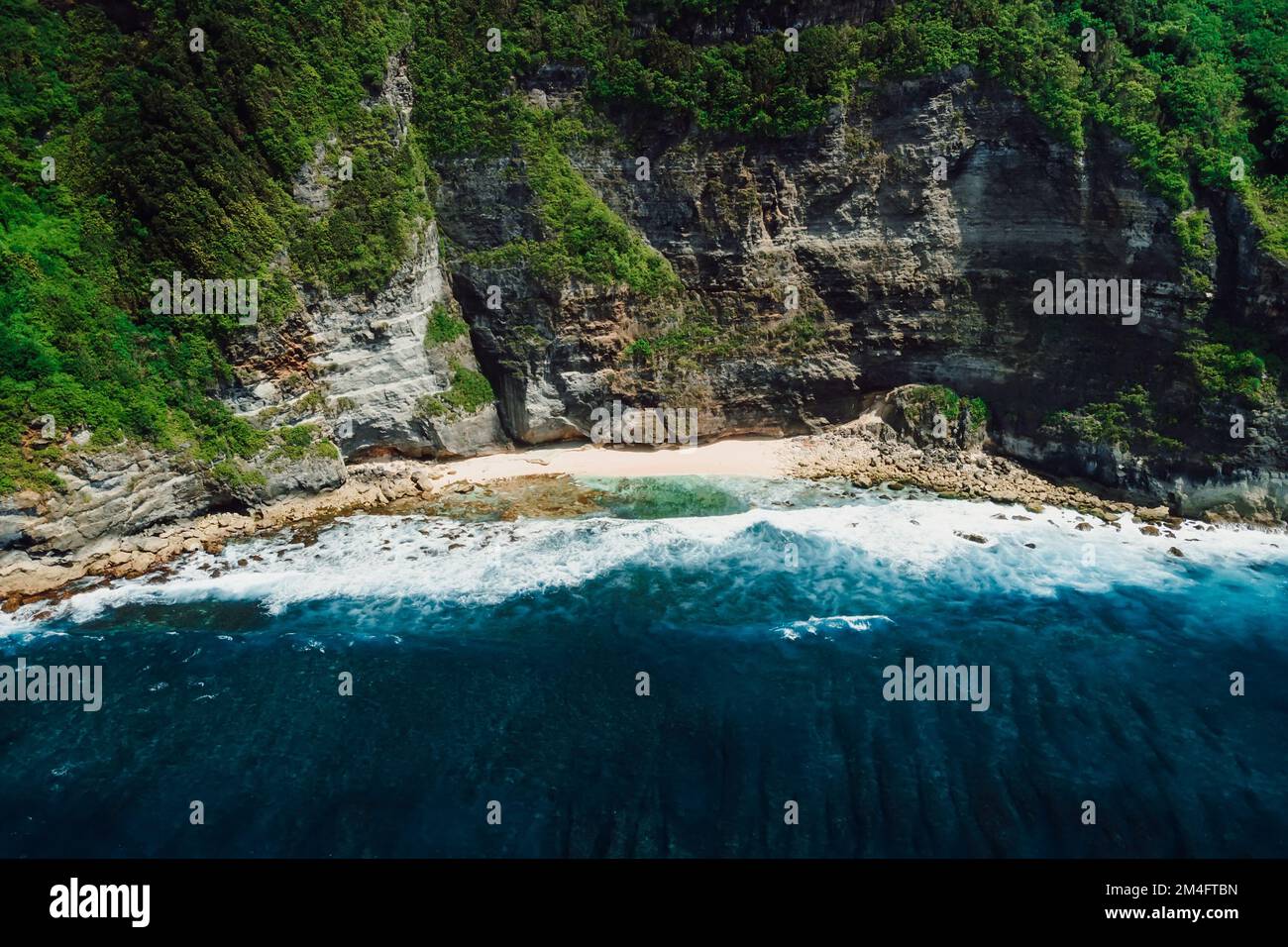 Meeresküste mit Strand, felsigen Klippen und Meer mit Wellen in Bali. Luftaufnahme. Stockfoto