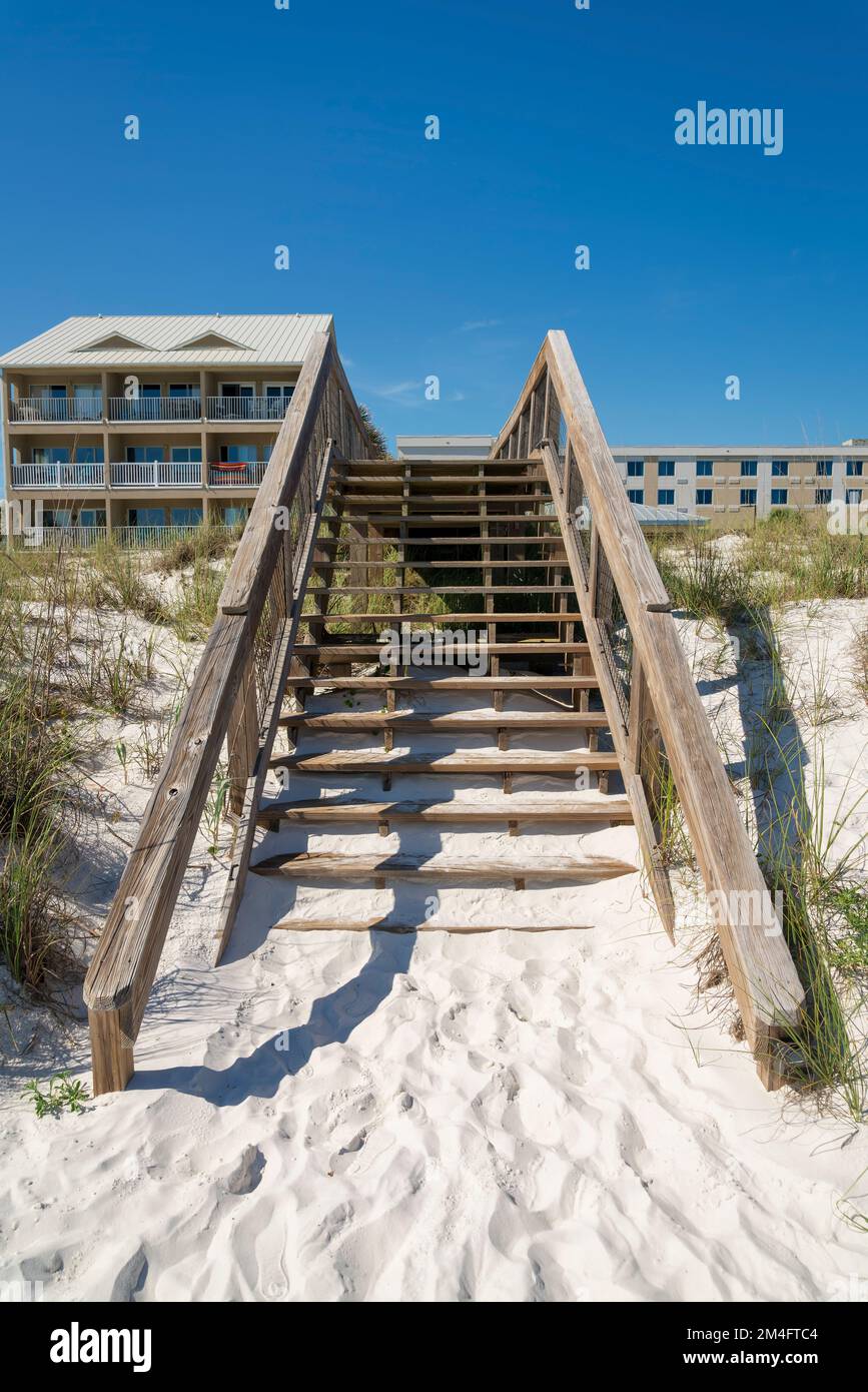 Treppen auf der Promenade über die weißen Sanddünen vor den Strandhäusern in Destin, FL. Holztreppen auf einer Promenade, die zur Strandhure führt Stockfoto