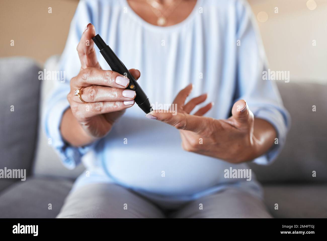 Schwangere Frau, Diabetes und Finger für Zuckertest, Gesundheit Wellness und Bluttest oder Senioren Schwangerenbetreuung auf dem Sofa im Wohnzimmer. Reife Mutter Stockfoto