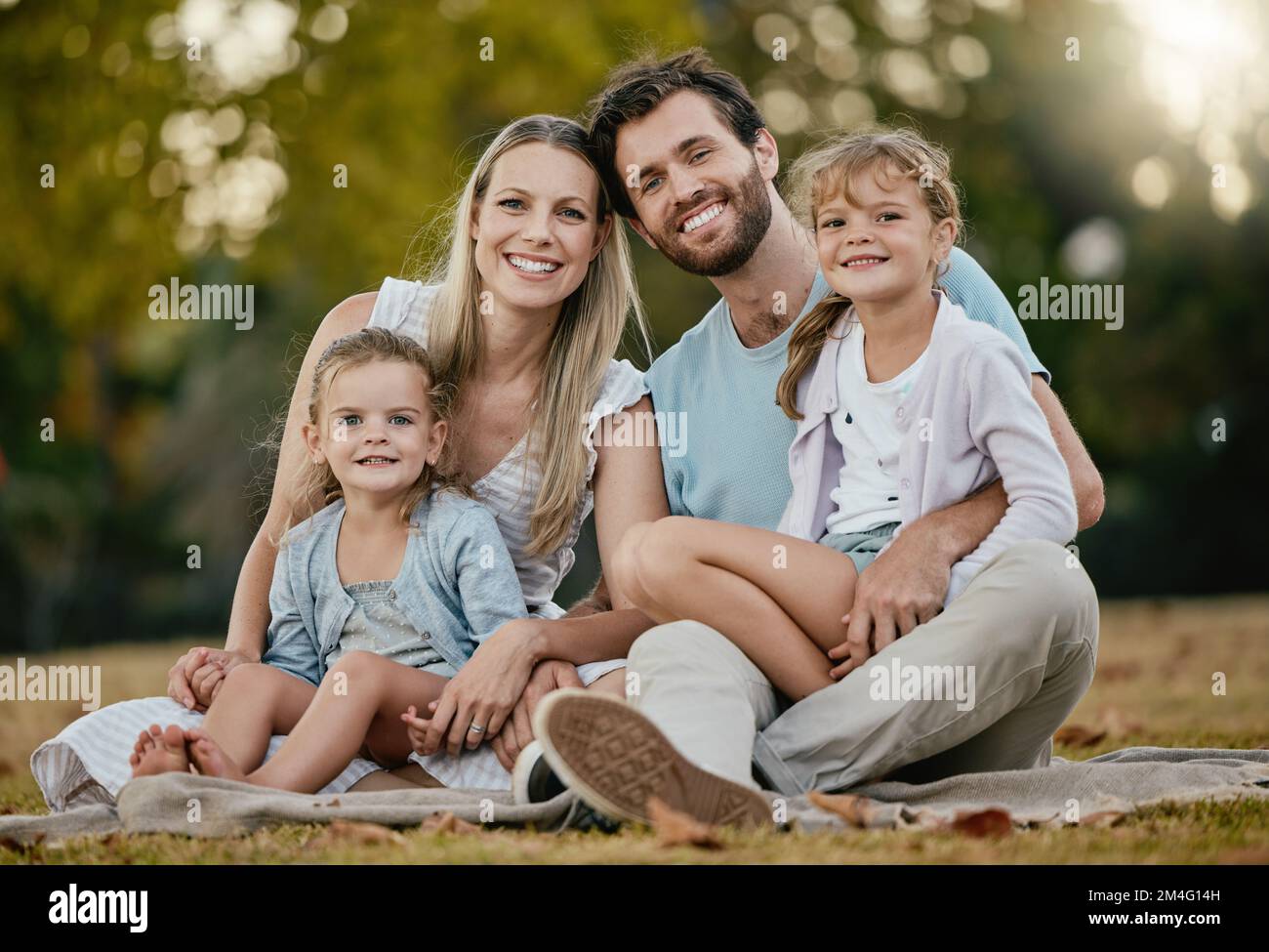 Familie, Park Picknick und Porträt mit Lächeln, Liebe und Glück für die Verbindung auf Decke, Gras und Sonnenschein. Junge, glückliche Familie, Rasen und Eltern mit Stockfoto