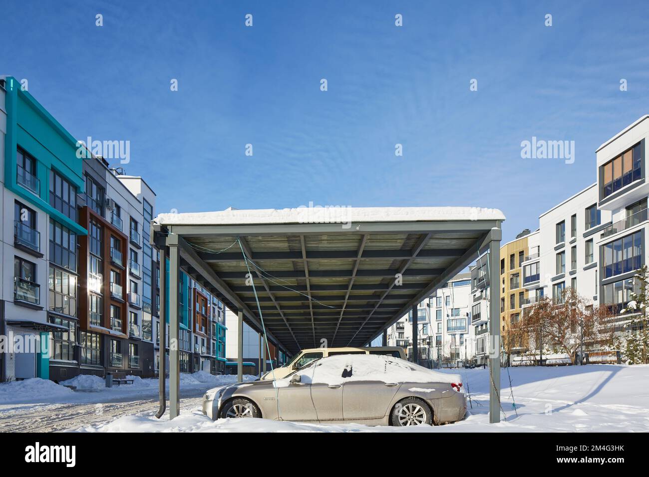 New Metal Carport für öffentliche Parkplätze vor Multi Residential Winter. Gebäude. Parkplätze im Freien unter dem Schneeplatz mit Auto. Stockfoto