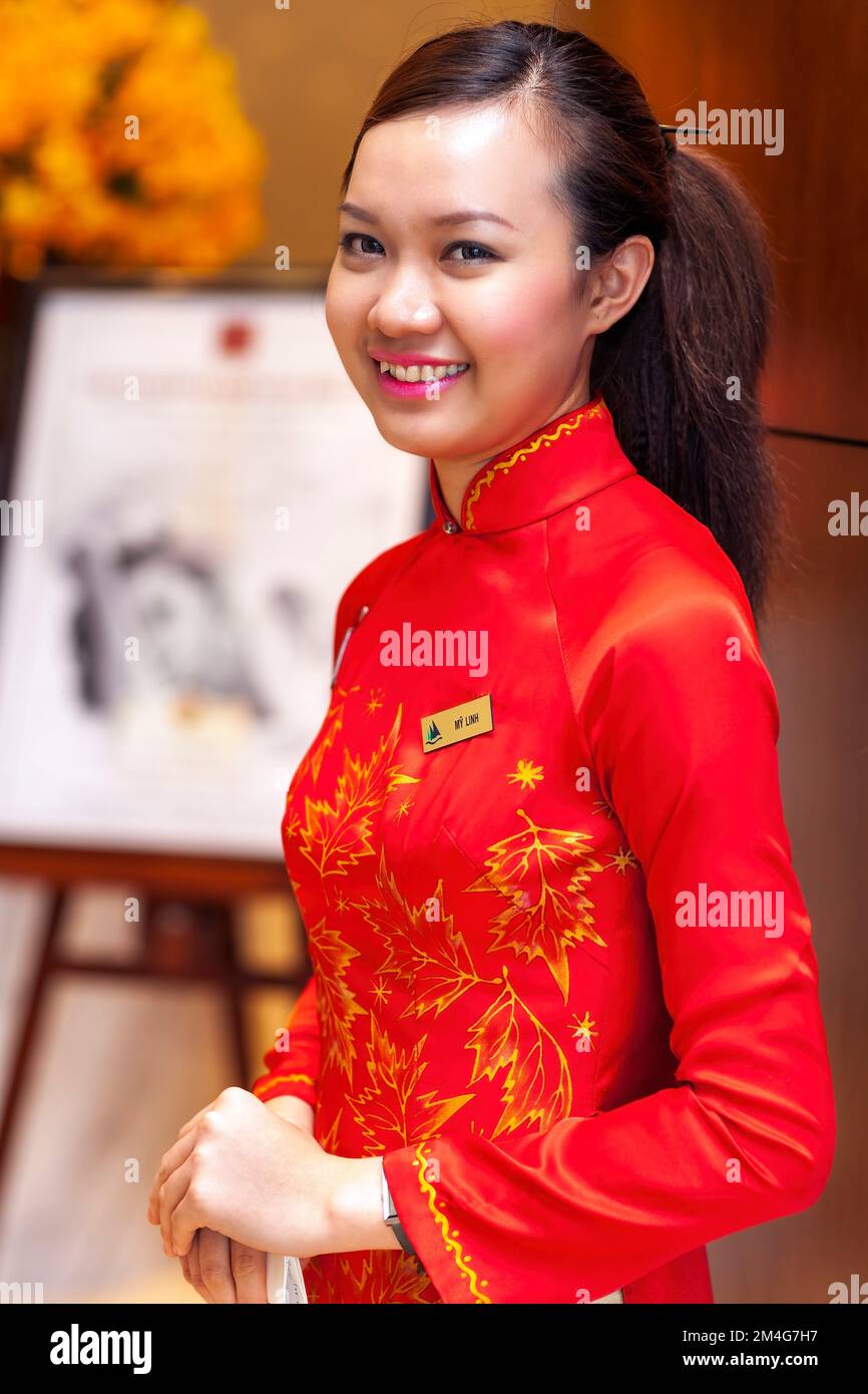 Hotelrezeptionistin trägt Ao dai, Saigon, Vietnam Stockfoto