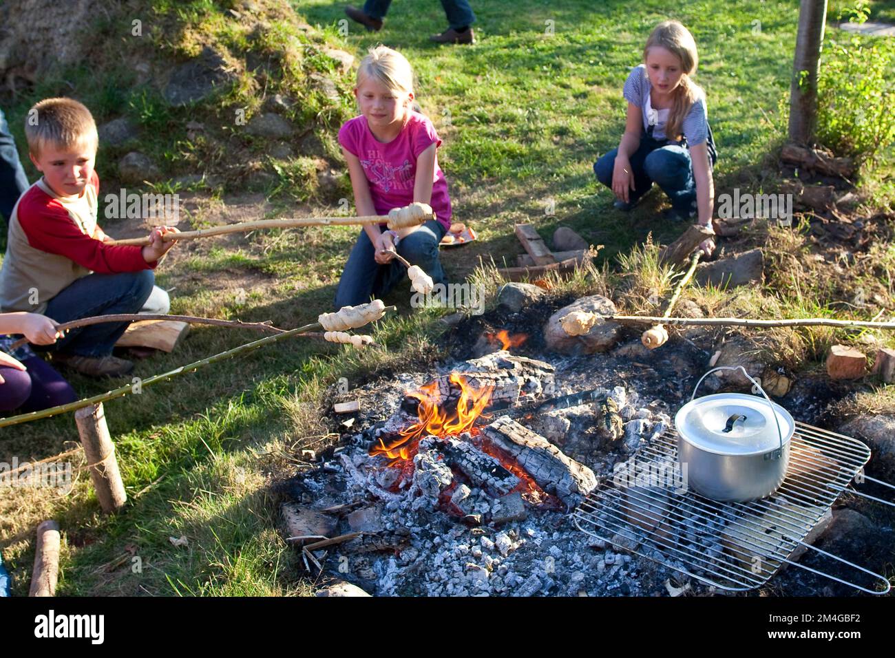 Kinder backen Brot am Lagerfeuer, Deutschland Stockfoto