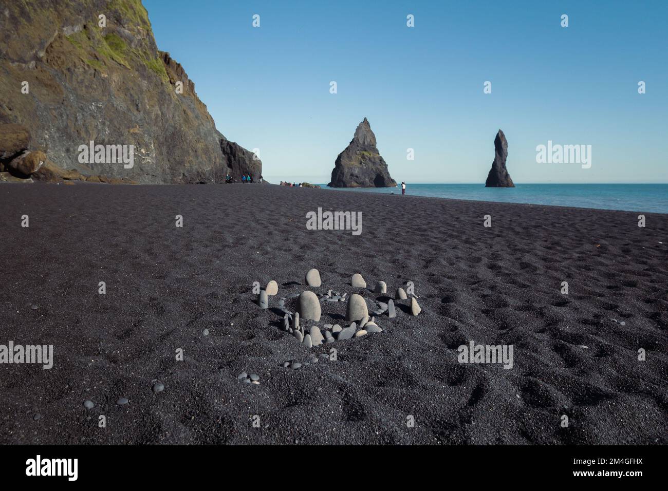 Nahaufnahme Steinkreis auf schwarzem Strandfoto Stockfoto