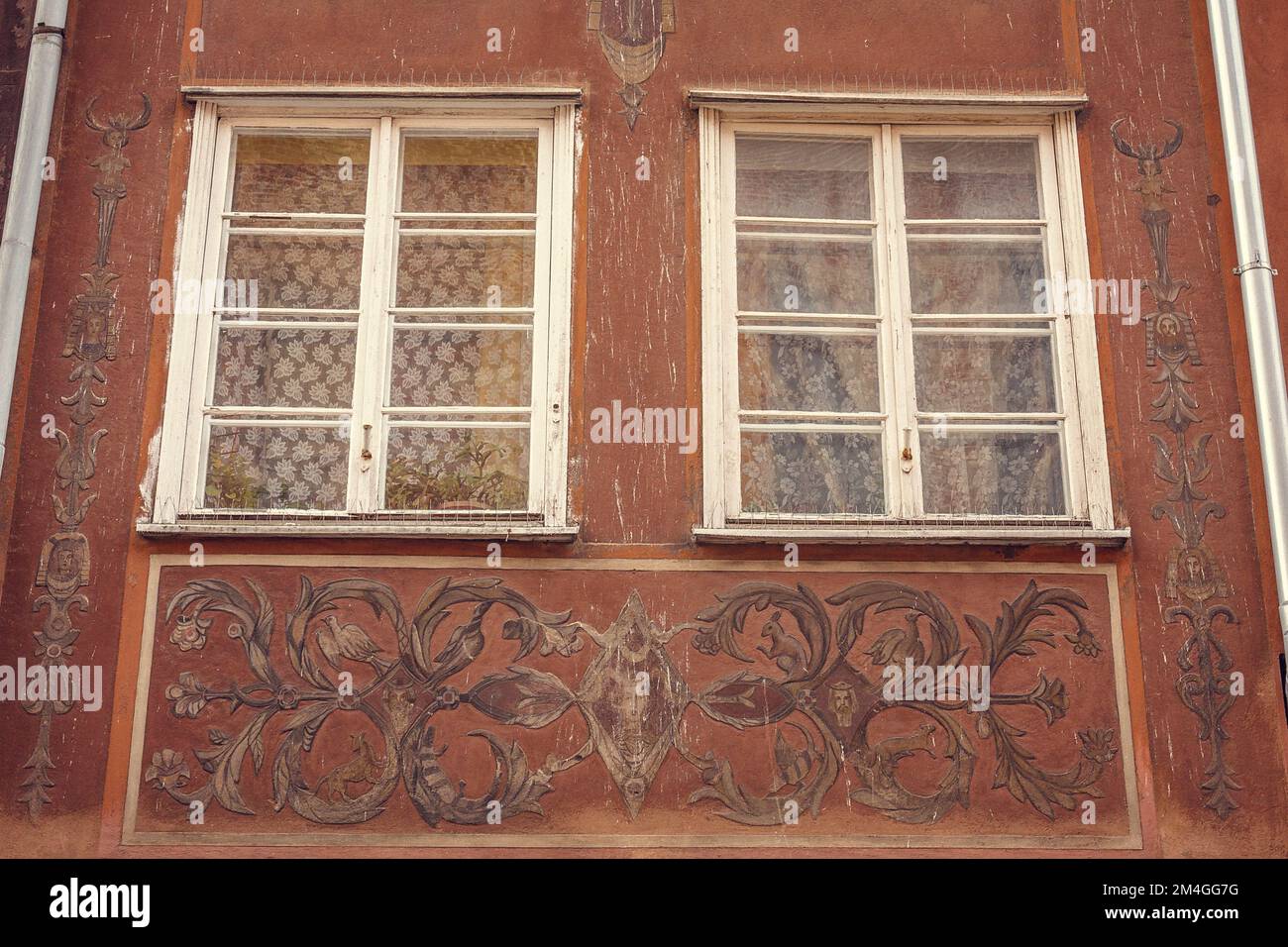 Beeindruckende alte Ornamente um die Fenster des Gebäudes, Außenfoto Stockfoto