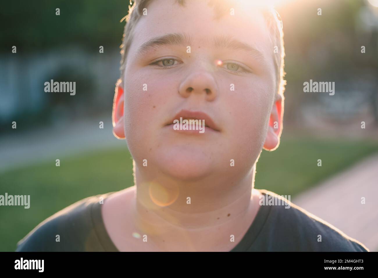 Nahaufnahme Porträt eines Jugendlichen Jungen in goldener Nachmittagssonne mit Linsenerleuchtung Stockfoto