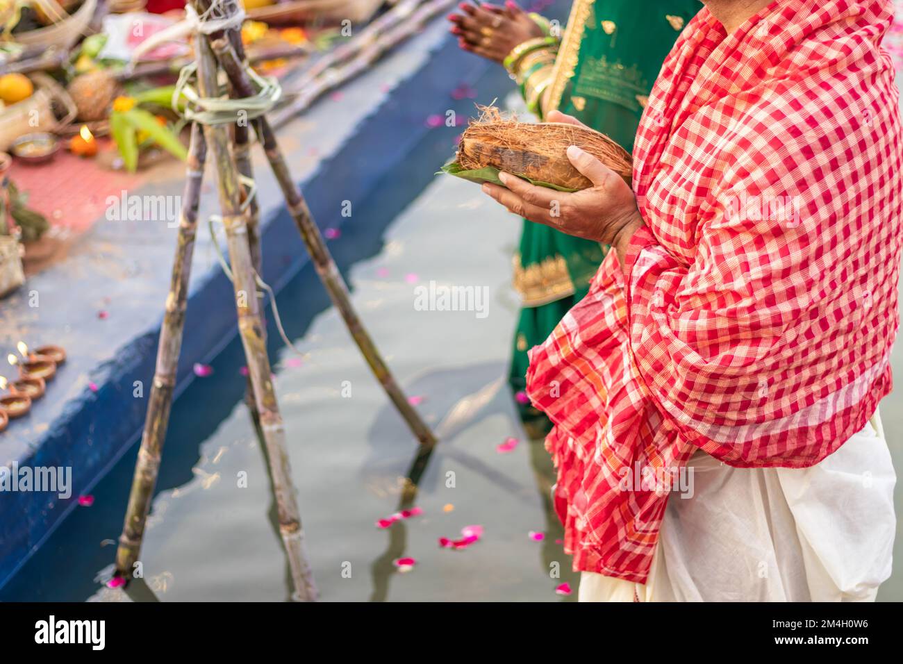 Ein Mann mit religiösen Opfern für den sonnengott während des Chhath Festivals aus flachem Winkel Stockfoto