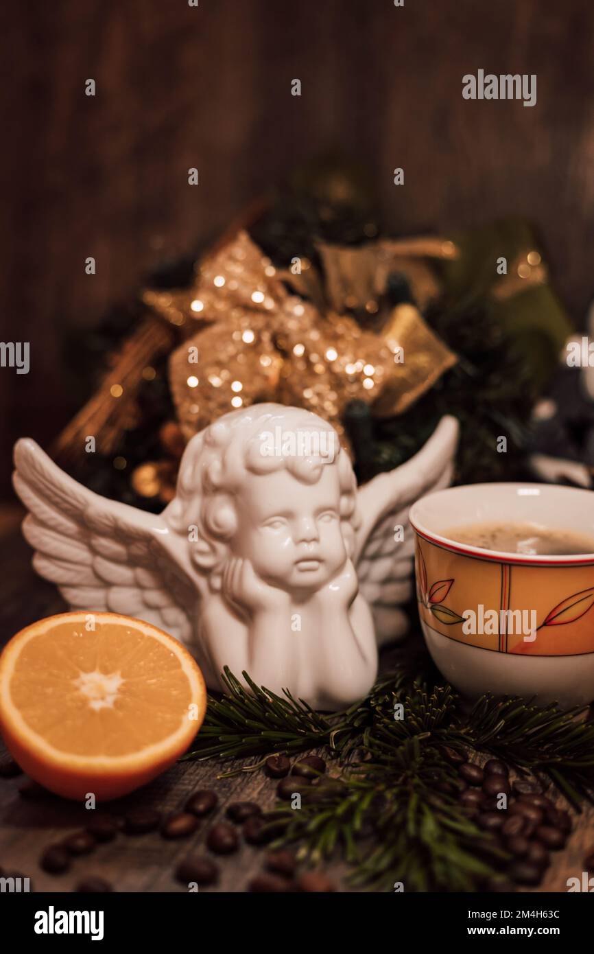 Weihnachtsengel, eine Tasse Kaffee, Orange auf einem dunklen Holztisch Stockfoto