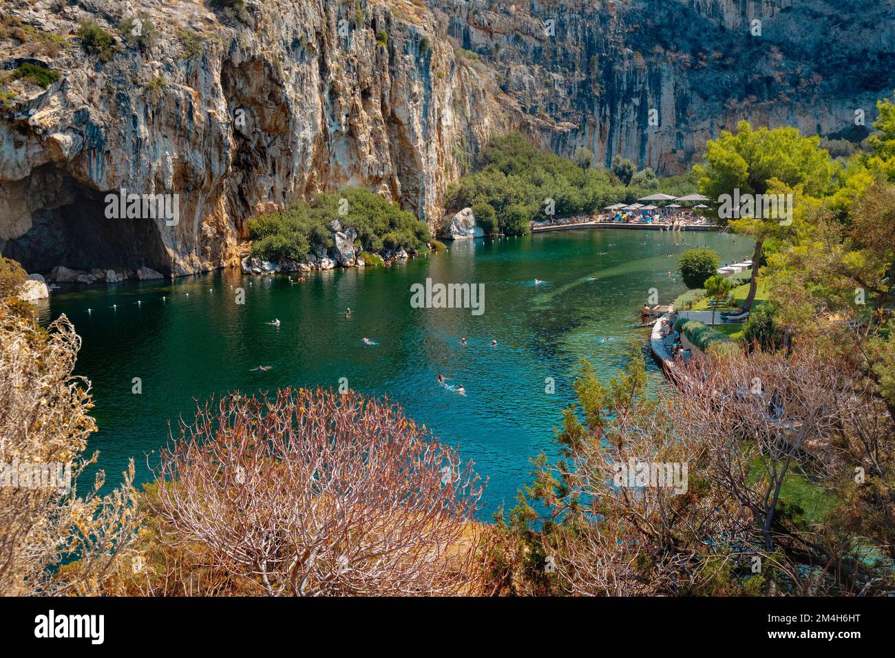 Vouliagmeni, Griechenland - 1. September 2022: Einige Menschen genießen das gute Wetter eines Sommertags auf dem See Vouliagmeni in Vouliagmeni, Griechenland Stockfoto