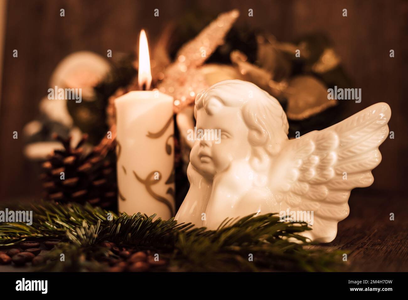 Weihnachtsengel-Komposition, Kerze und Kaffeebohnen auf einem dunklen Tisch Stockfoto