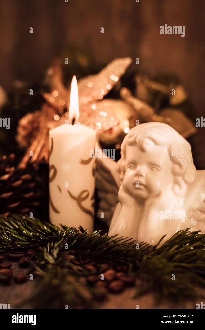 Weihnachtsengel-Komposition, Kerze und Kaffeebohnen auf einem dunklen Tisch Stockfoto