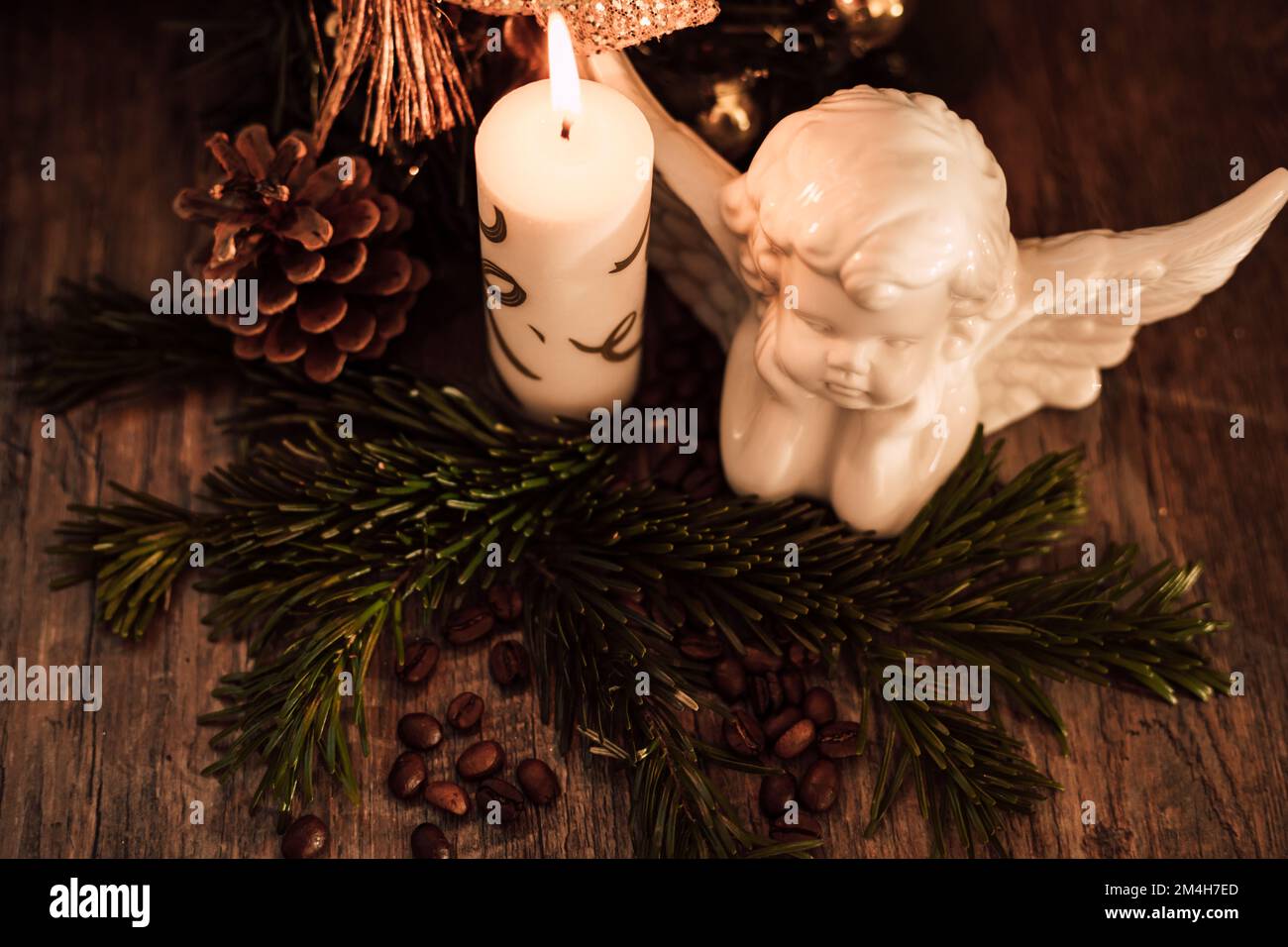 Weihnachtsengel-Komposition, Kerze und Kaffeebohnen auf einem dunklen Tisch Stockfoto