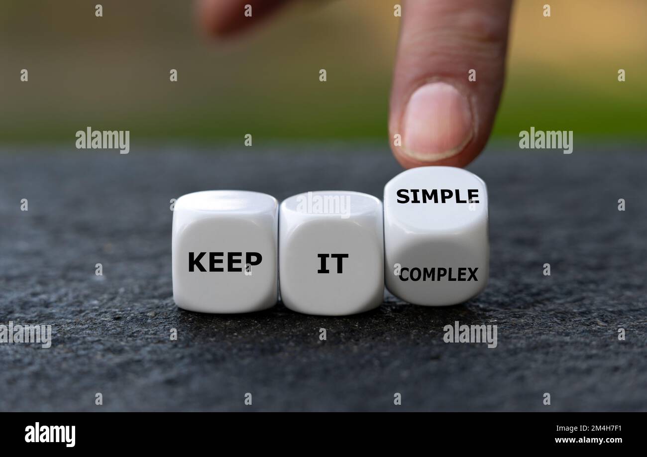 Die Hand würfelt und ändert den Ausdruck „Keep it complex“ in „Keep it simple“. Stockfoto