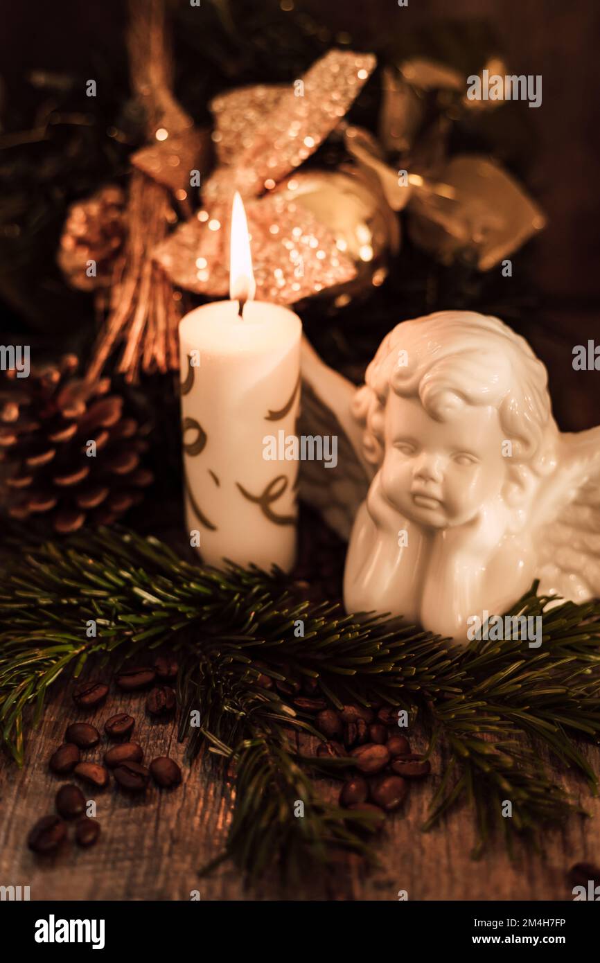 Weihnachtsengel-Komposition, Kerze und Kaffeebohnen auf einem dunklen Tisch Stockfoto