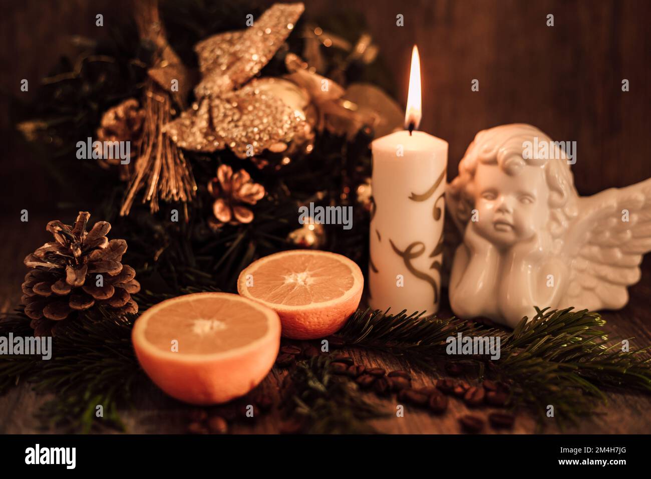 Weihnachtsengel-Komposition, Kerze und Kaffeebohnen auf einem dunklen Tisch Stockfoto