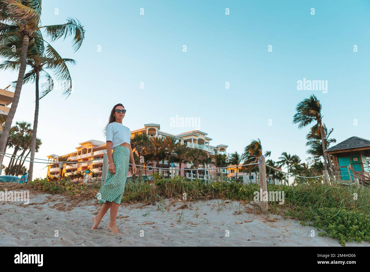 Junge glückliche Frau am Strand genießt ihren Sommerurlaub Stockfoto