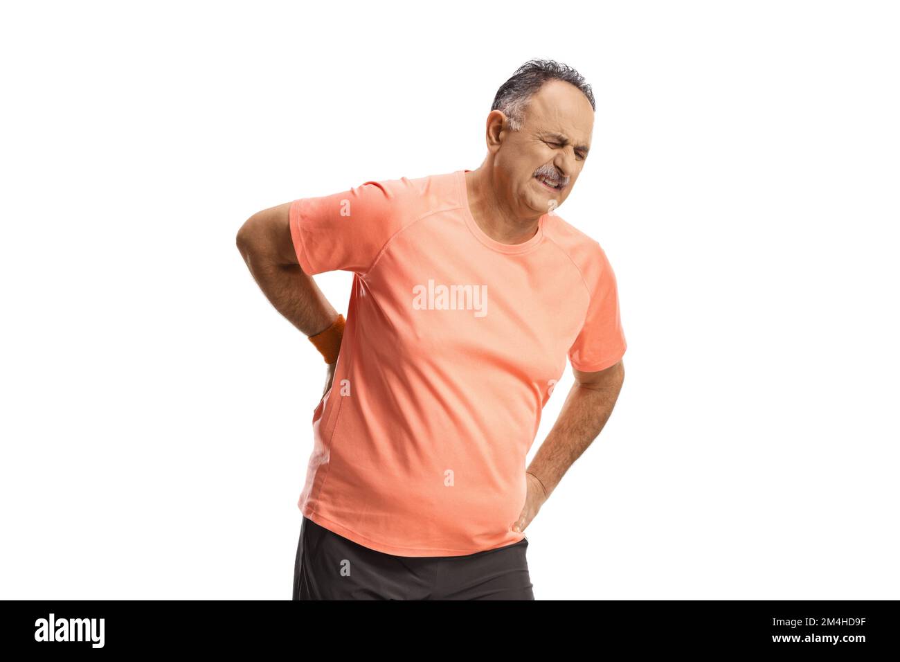 Reifer Mann in Sportbekleidung, der seine schmerzhafte Wirbelsäule isoliert auf weißem Hintergrund hält Stockfoto
