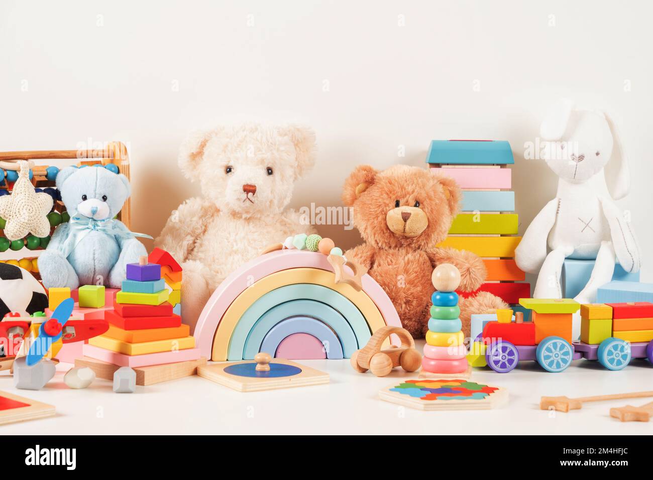 Pädagogische Spielzeugsammlung für Kinder Teddybär, Holzflugzeug, Zug, Abacus, Regenbogen, Pädagogisches Babyspielzeug aus Holz auf weißem Hintergrund. Nachhaltig, umweltfreundlich Stockfoto