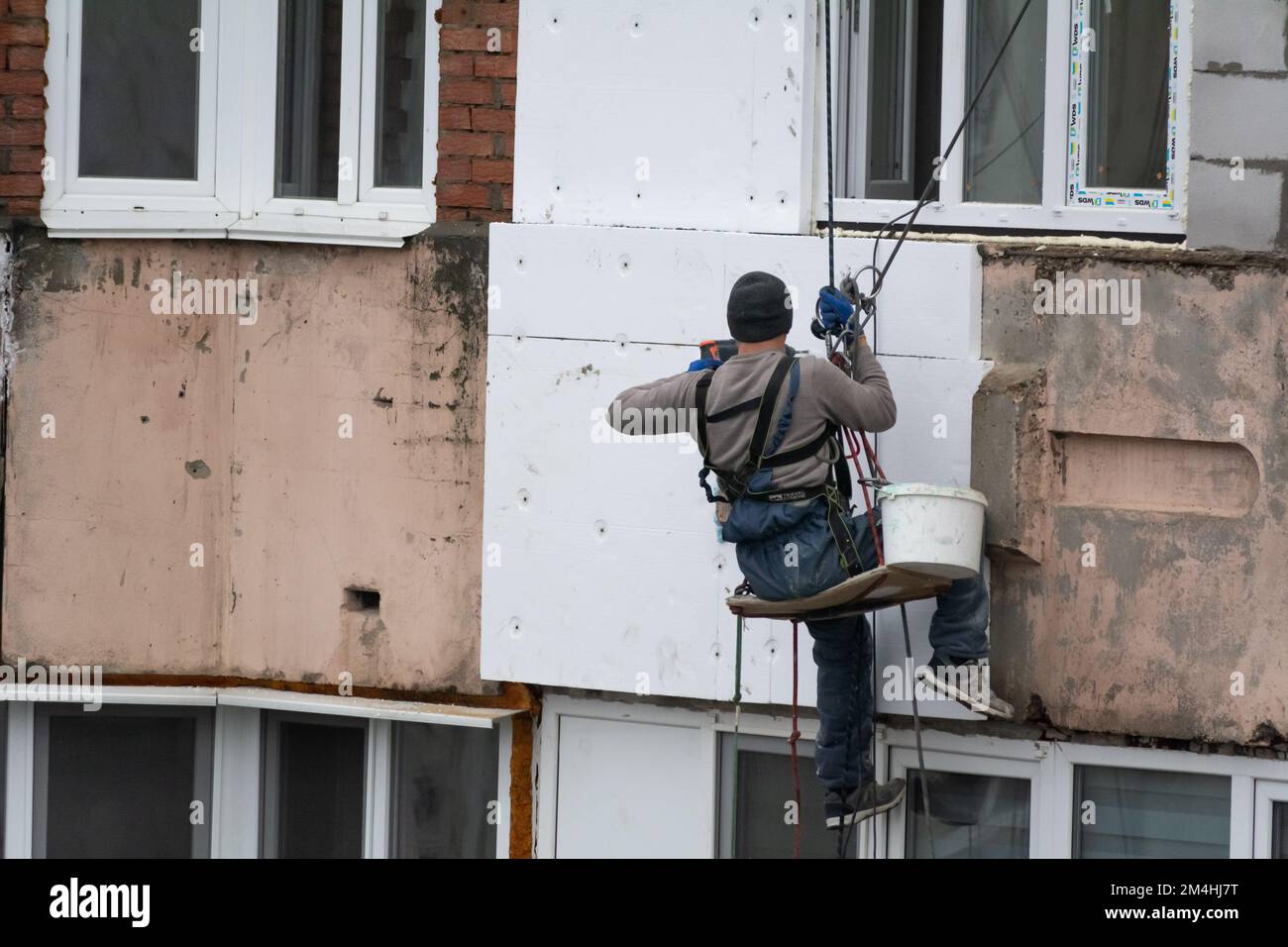 Isolierung des Hauses mit Polyfoam. Der Arbeiter installiert eine  Styroporplatte an der Fassade Stockfotografie - Alamy