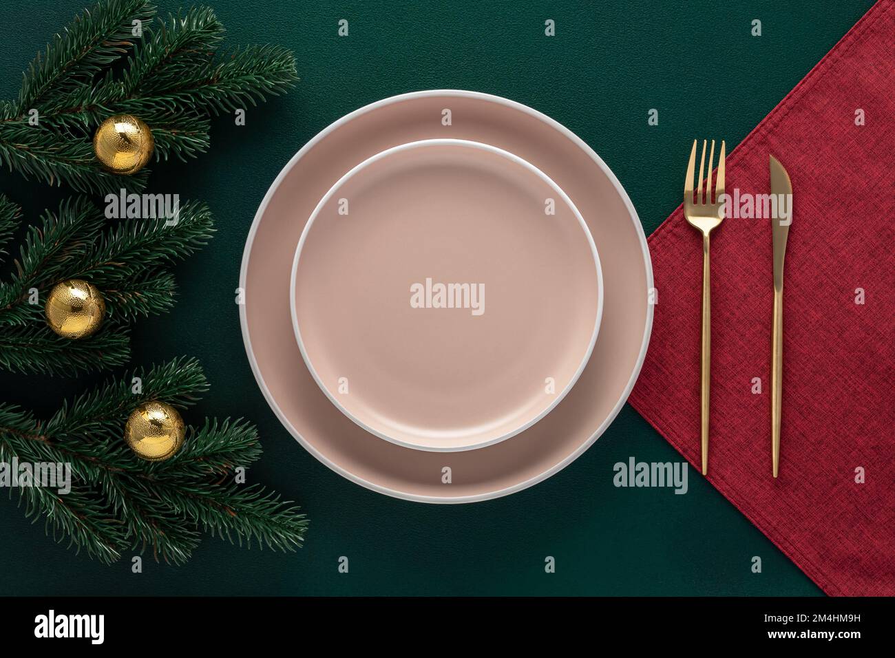 Weihnachtstisch mit Neujahrsdekoration. Leere Teller und goldenes Besteck auf dunkelgrün. Geschirr. Draufsicht. Speisen, festliche Einrichtung in einer Lux Stockfoto