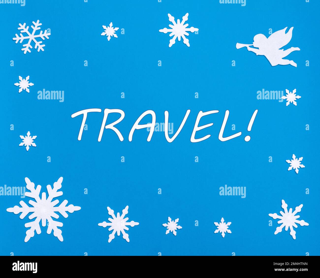 Frohe Weihnachten und Frohes neues Jahr. Der Text Reise auf blauem Hintergrund mit Weihnachts-Schneeflocken, einem weißen Engel. Reisen, Geschäftsreisen. Stockfoto