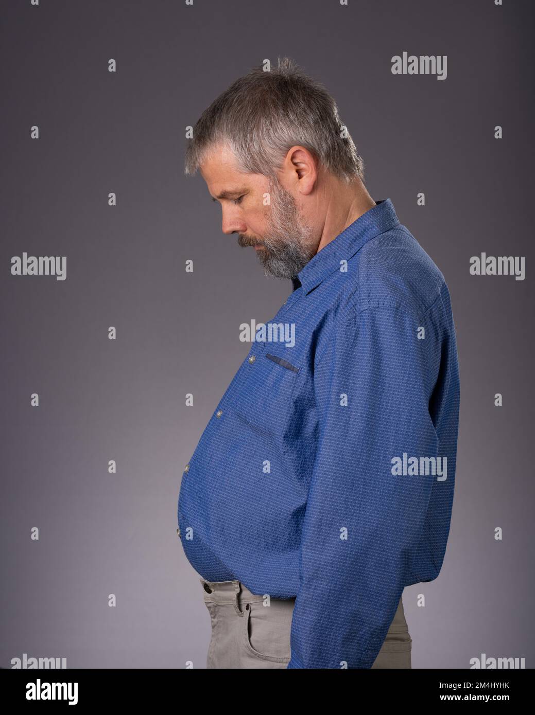Mann 55 Jahre im Studio, fetter Bauch Stockfoto