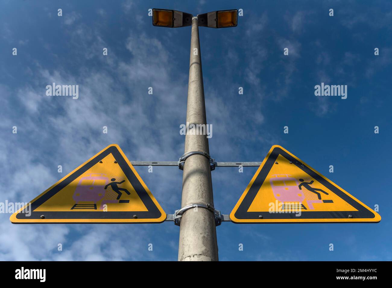 Lichtmast mit Warnschildern auf einem Bahnsteig in Bayern Stockfoto