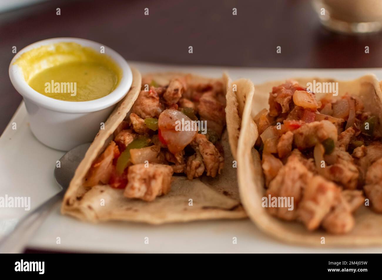Blick auf Hühnchen-Tacos, serviert auf dem Tisch mit Sauce. Köstliche ...