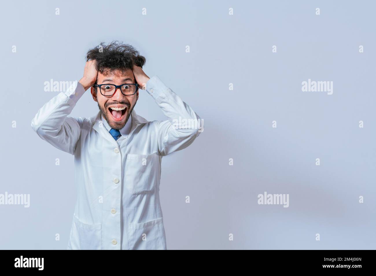 Ein verrückter Wissenschaftler, der seine Haare auf isoliertem Hintergrund auszieht. Verrückter Wissenschaftler, der sich die Haare schnappt, mit einem isolierten verrückten Gesicht. Ein Arzt mit einem verrückten Gesicht Stockfoto