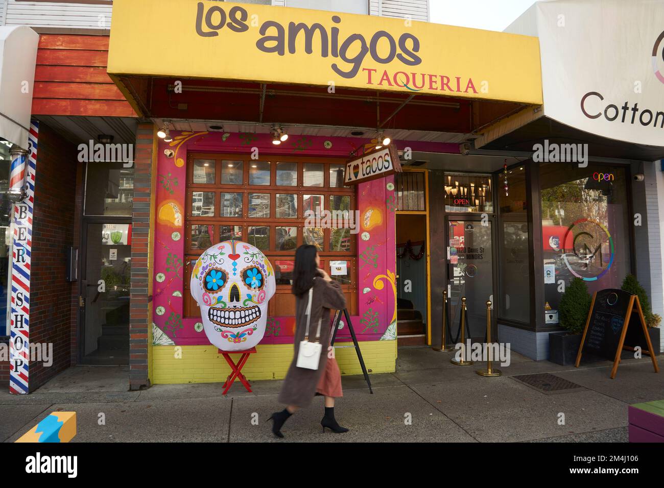 Frau, die an der farbenfrohen Fassade des mexikanischen Restaurants Los Amigos Taqueria in der Davie Street im West End, Vancouver, BC, Kanada vorbeigeht Stockfoto