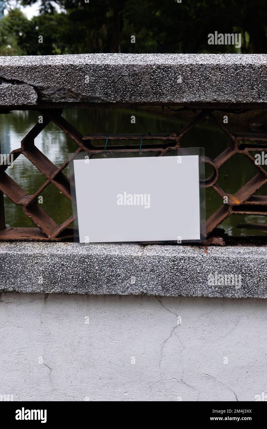 Ein leeres, weiß laminiertes Schild, das an einer Brücke angebracht ist Stockfoto