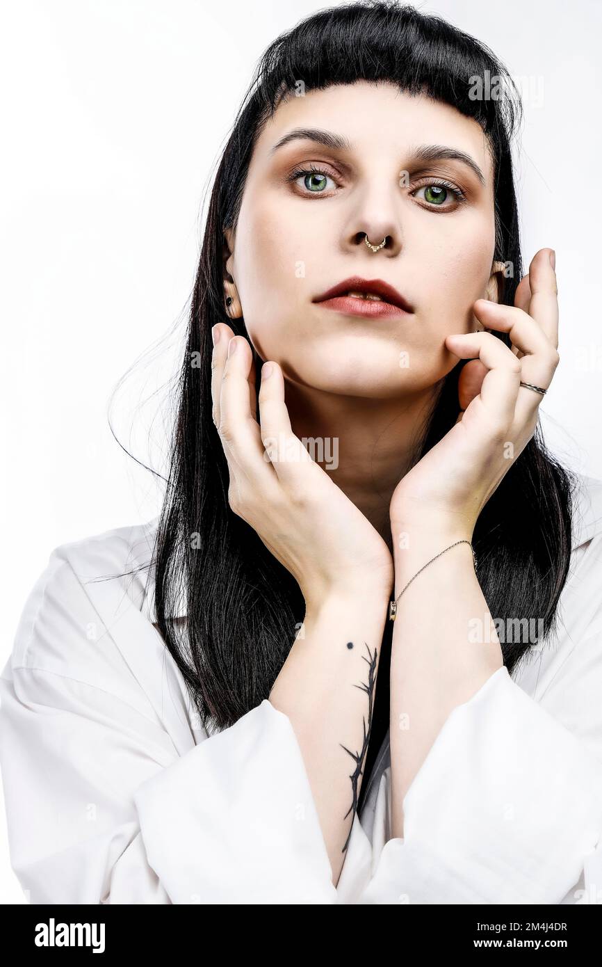 Porträtieren Sie eine junge Frau mit langen schwarzen Haaren und roten Lippen, ein gotisches Mädchen Stockfoto
