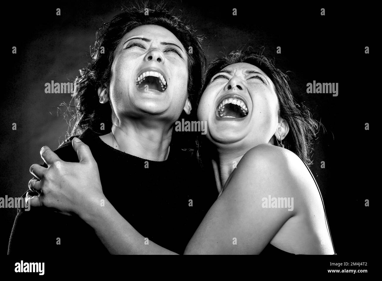 Zwei asiatische Frauen, Schwestern, koreanische Geschwister, umarmen, schreien, Mund öffnen, Schwarzweiß-Aufnahme Stockfoto