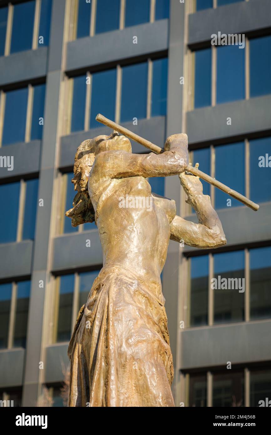 Eine Frau spielt eine Flöte in der Innenstadt von Greenville, South Carolina, mit einem Gebäude im Hintergrund. Stockfoto