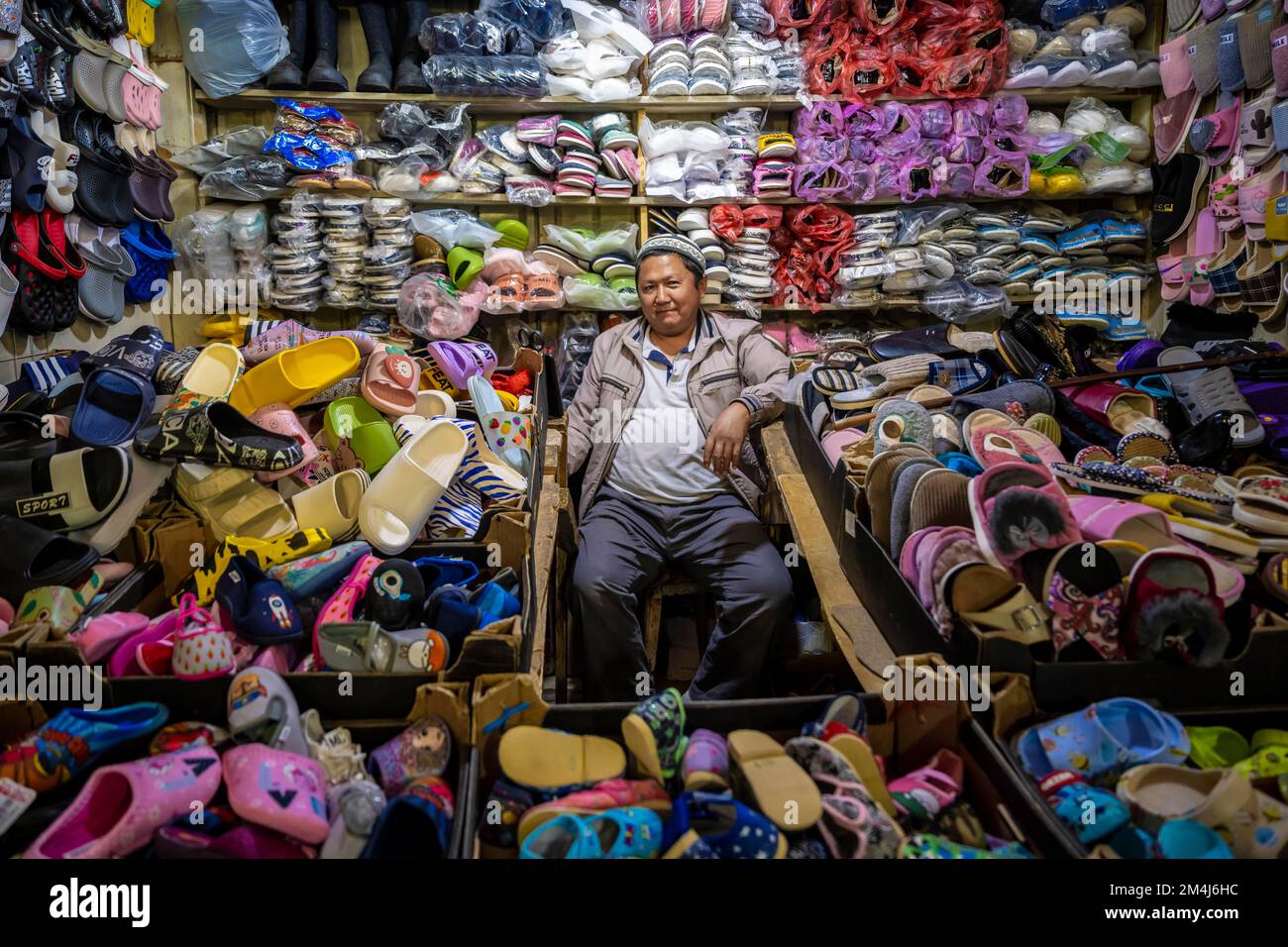 Schuhverkäufer in seinem Stand, sehr viele Schuhe, Osh Bazaar, Kirgisistan, Zentralasien Stockfoto