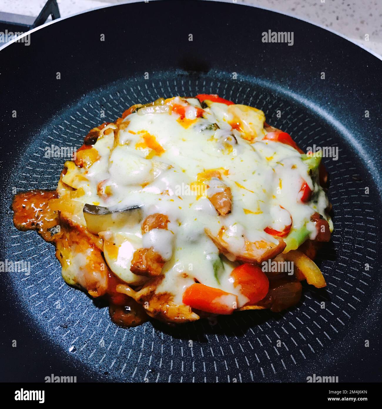 Ich mache eine Mini-Tortilla-Mozzarella-Kombinationspizza in der Pfanne Stockfoto
