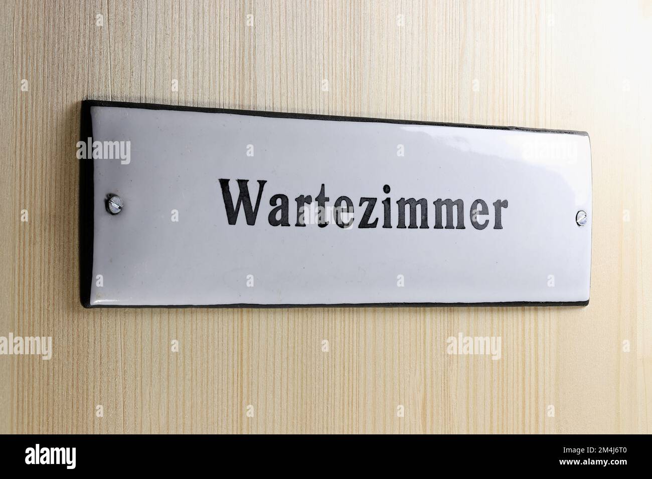 Ein emailliertes Schild an der Tür zum Wartezimmer einer deutschen Arztpraxis Stockfoto