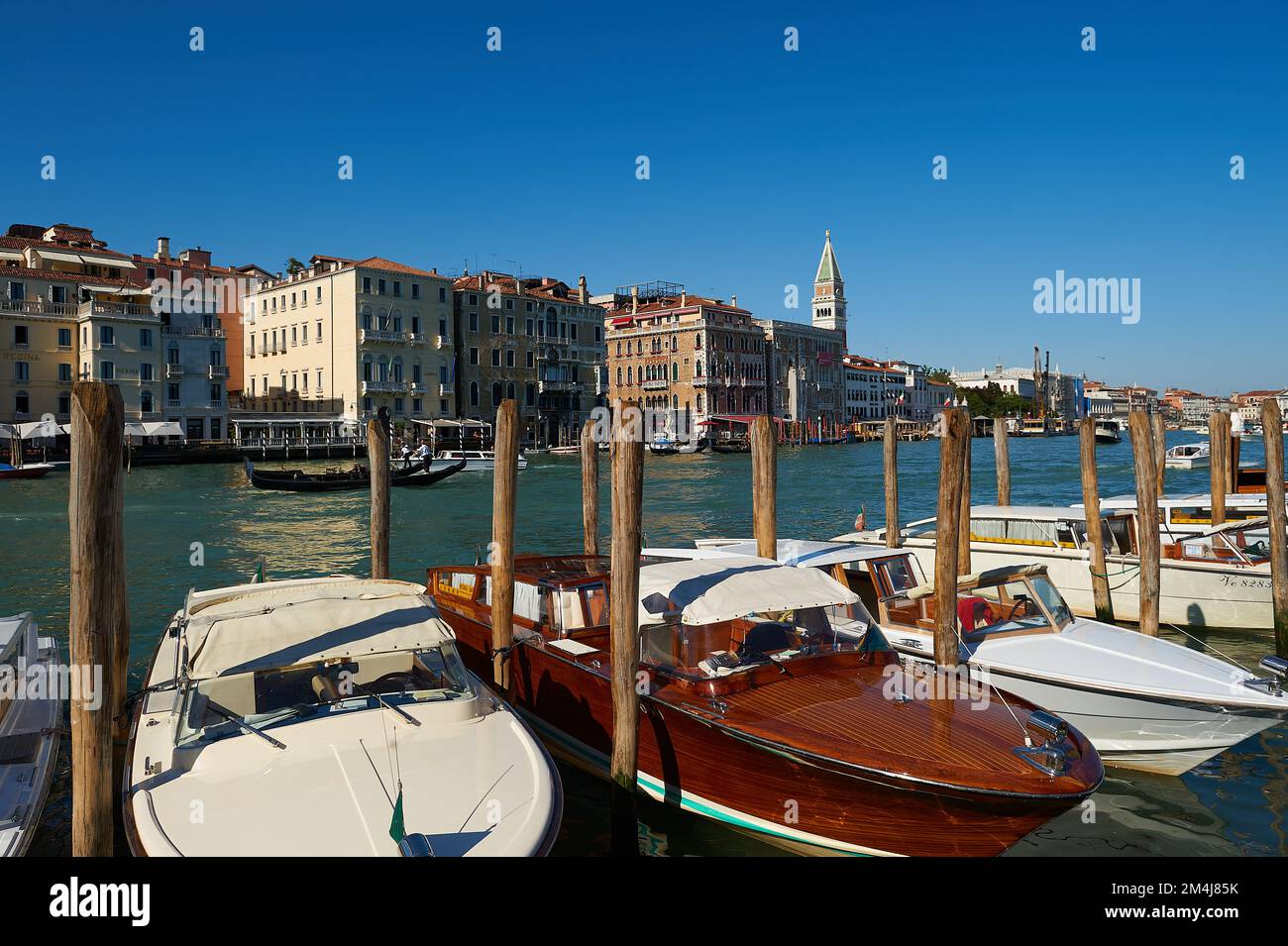 Pier von Venedig mit festgemachtem venezianischen Taxi und Blick auf den Canal Grande mit seinen berühmten Gebäuden im Hintergrund Stockfoto