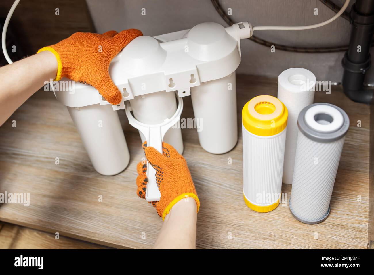 Der Installateur installiert oder wechselt den Wasserfilter. Ersatz-Aqua-Filter. Stockfoto