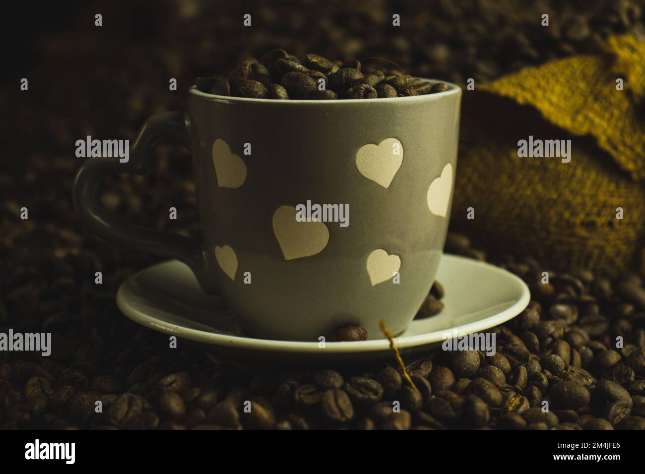 Eine Tasse Kaffee über Kaffeebohnen in einem Leinenbeutel Stockfoto